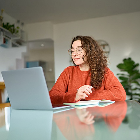 A woman looking at her laptop screen.